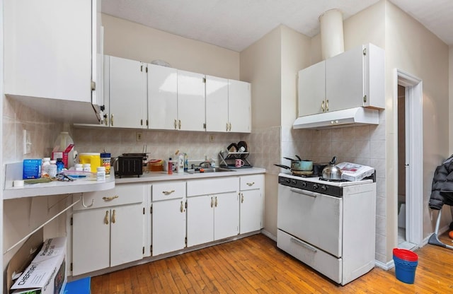 kitchen featuring backsplash, white range, sink, light wood-type flooring, and white cabinetry