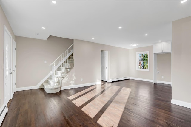 unfurnished living room with dark wood-type flooring and a baseboard radiator