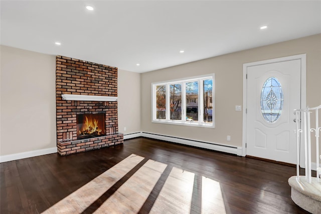 entryway featuring a brick fireplace, dark hardwood / wood-style floors, and a baseboard heating unit