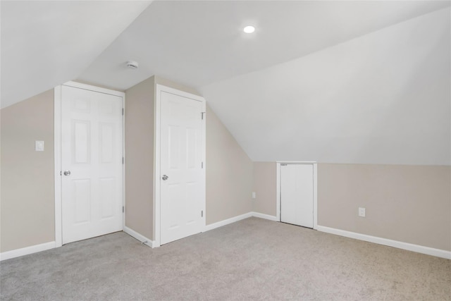 bonus room featuring vaulted ceiling and light carpet