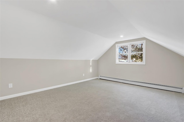 additional living space featuring vaulted ceiling, a baseboard radiator, and carpet