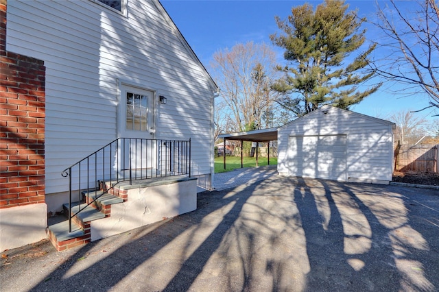 view of home's exterior with a carport, a garage, and an outdoor structure