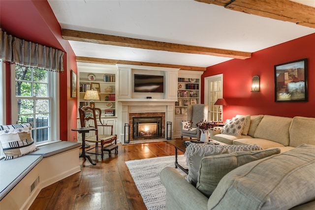 living room featuring dark hardwood / wood-style flooring, built in features, and beam ceiling