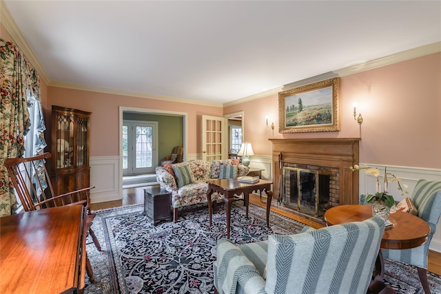 living room featuring a brick fireplace, ornamental molding, and wood-type flooring