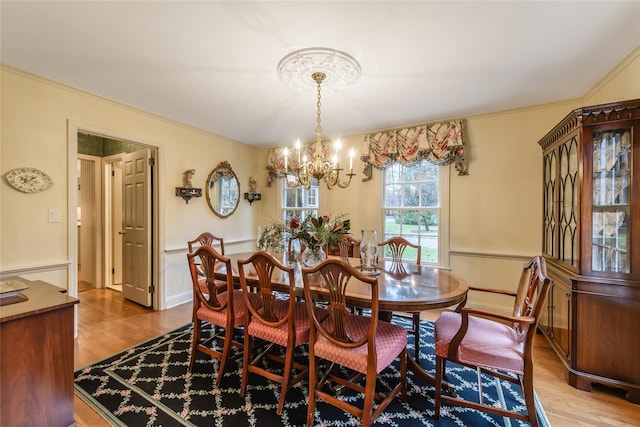 dining area with light wood-type flooring and a notable chandelier