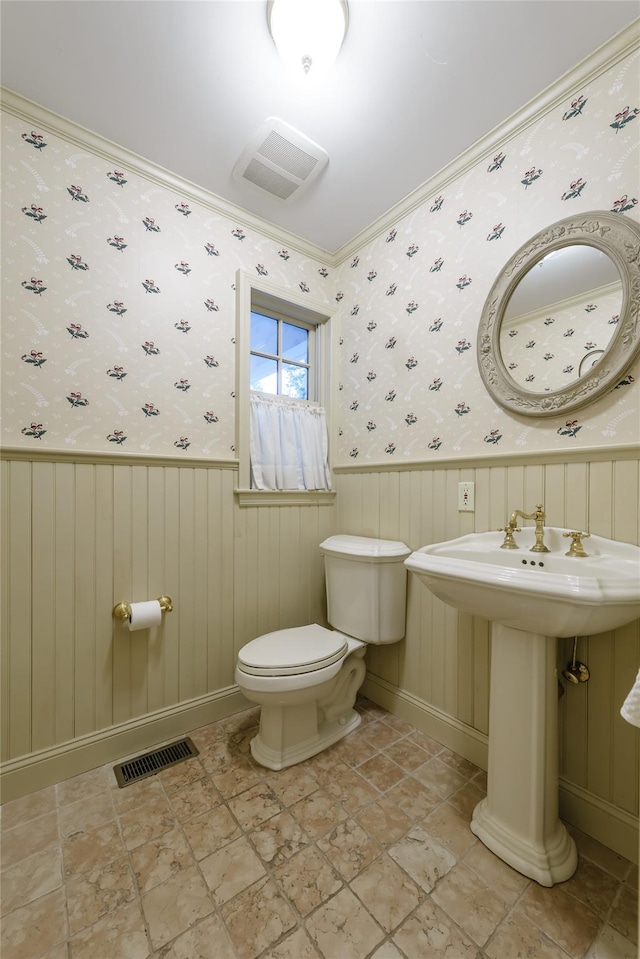 bathroom with crown molding and toilet