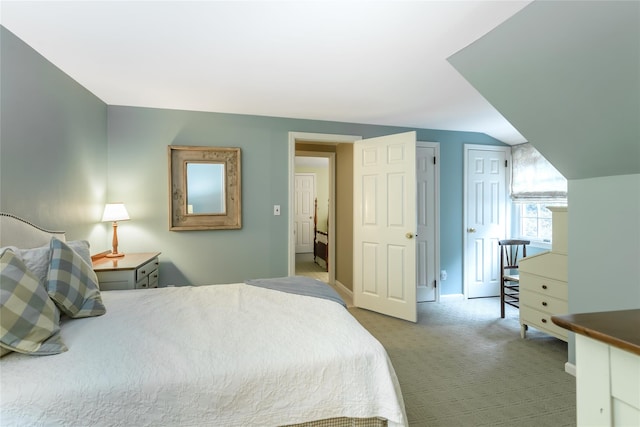 bedroom featuring light colored carpet and lofted ceiling