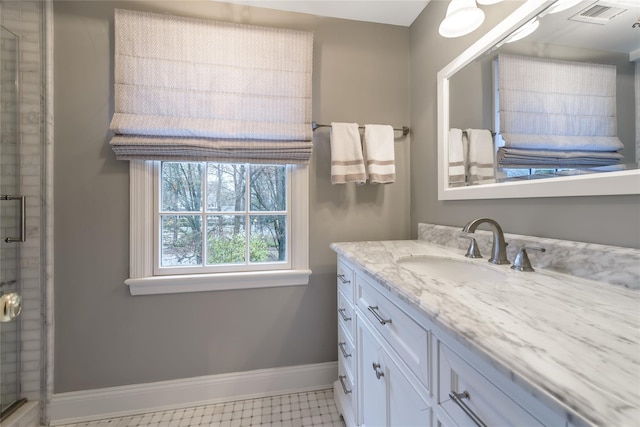 bathroom featuring a shower with door and vanity