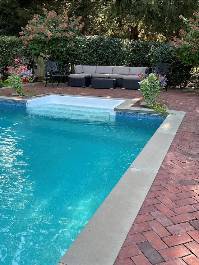 view of pool featuring outdoor lounge area and a patio