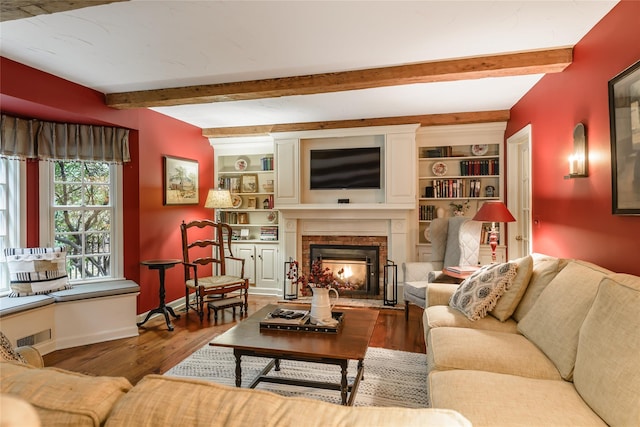 living room with beam ceiling, built in shelves, and hardwood / wood-style floors