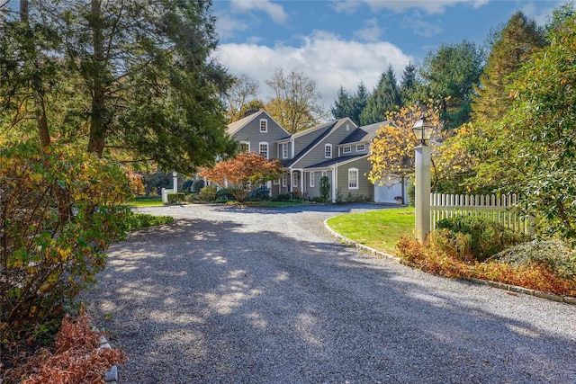 view of front of house with gravel driveway and fence