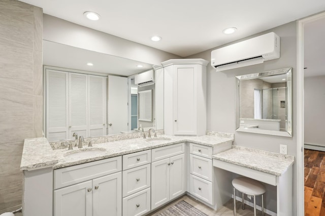 bathroom featuring an AC wall unit, vanity, and baseboard heating