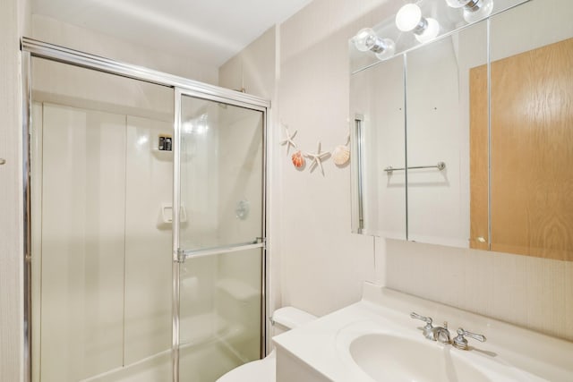 bathroom featuring an enclosed shower, vanity, and toilet