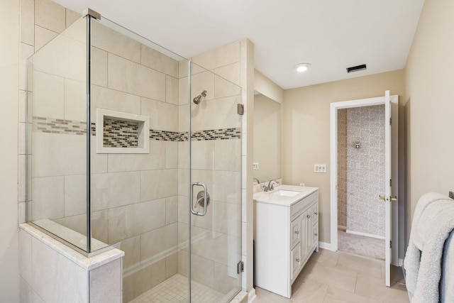 bathroom with tile patterned flooring, vanity, and walk in shower