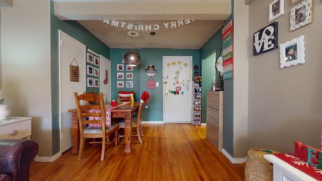 dining room featuring hardwood / wood-style floors and beam ceiling