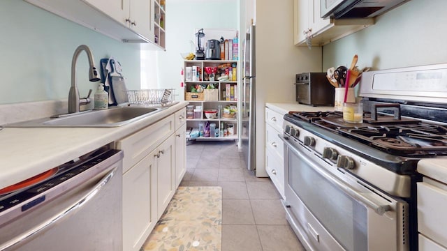 kitchen with white cabinets, light tile patterned floors, sink, and appliances with stainless steel finishes