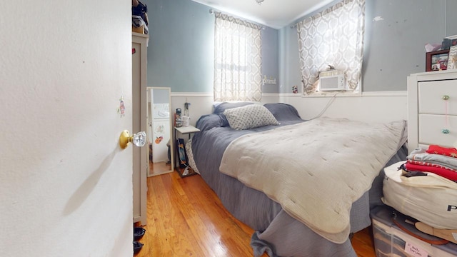 bedroom featuring wood-type flooring and cooling unit