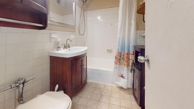 full bathroom featuring tile patterned floors, toilet, shower / bathtub combination with curtain, and tile walls