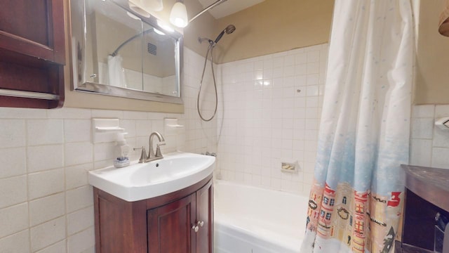 bathroom featuring vanity, tile walls, and shower / tub combo