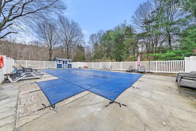 view of pool with a patio area and a storage unit