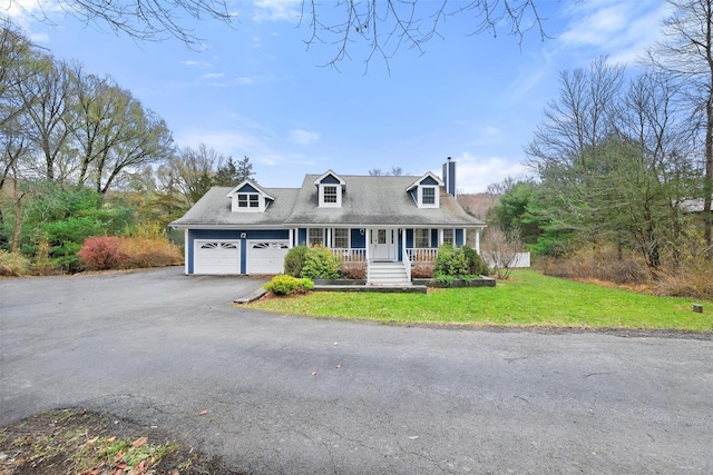 cape cod-style house featuring covered porch, a garage, and a front yard