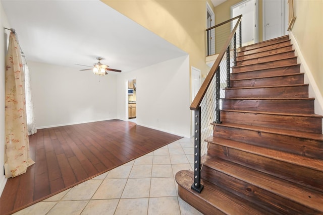 stairway with tile patterned flooring and ceiling fan