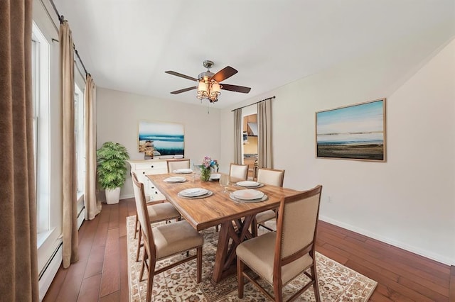 dining area featuring dark hardwood / wood-style flooring, ceiling fan, and a baseboard heating unit