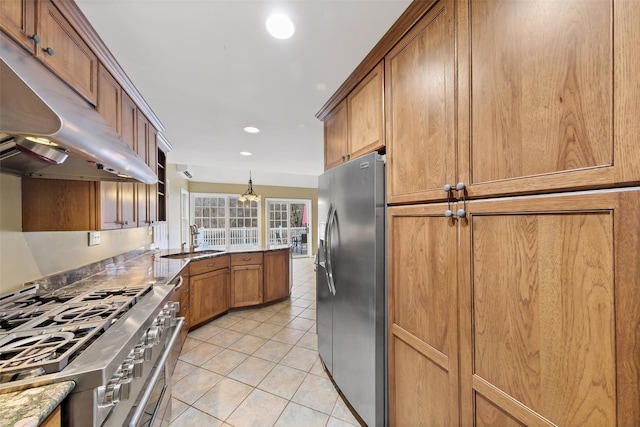 kitchen with light stone countertops, sink, decorative light fixtures, light tile patterned floors, and appliances with stainless steel finishes