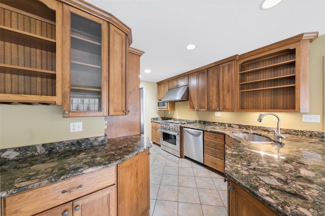 kitchen featuring light tile patterned floors, stainless steel appliances, dark stone countertops, and sink