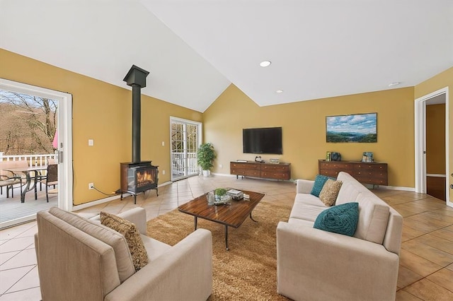 living room with a wood stove, plenty of natural light, and light tile patterned flooring