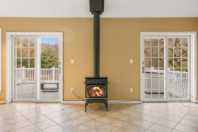 unfurnished living room with light tile patterned floors and a wood stove