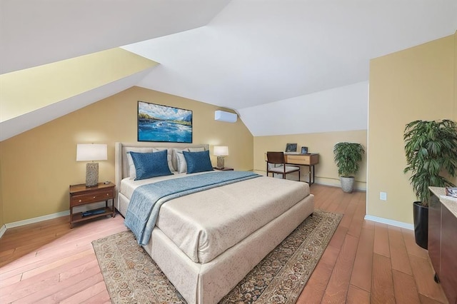 bedroom with light hardwood / wood-style floors and lofted ceiling