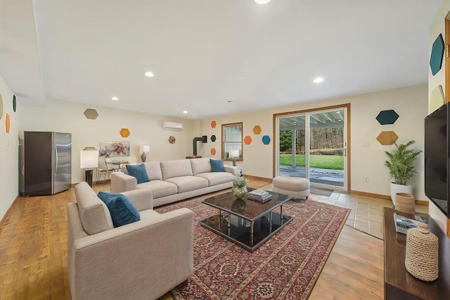 living room featuring a wall mounted air conditioner and light hardwood / wood-style floors