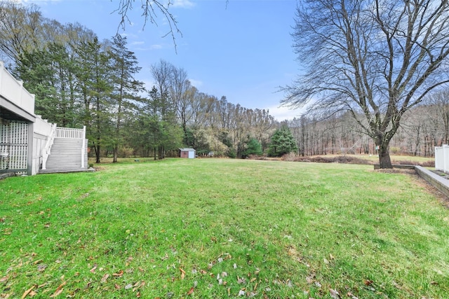 view of yard with a wooden deck and a storage unit