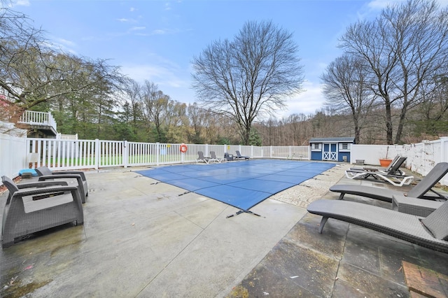 view of swimming pool with an outbuilding and a patio