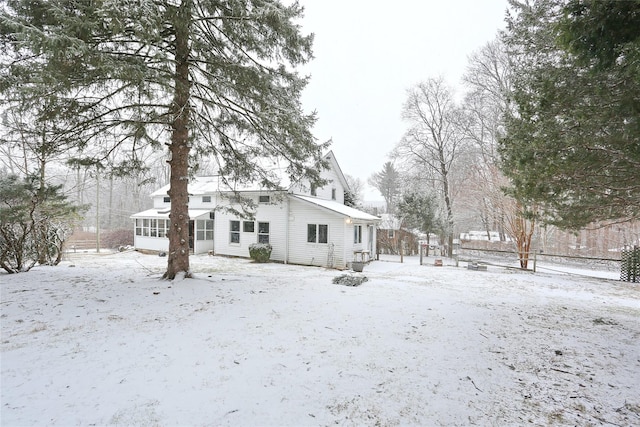 snow covered property featuring a sunroom