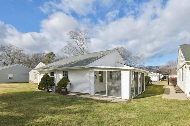 back of property with central AC, a sunroom, and a yard