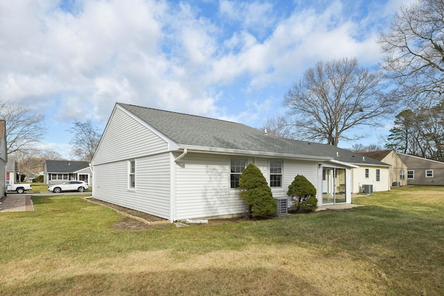 view of side of property featuring cooling unit and a lawn