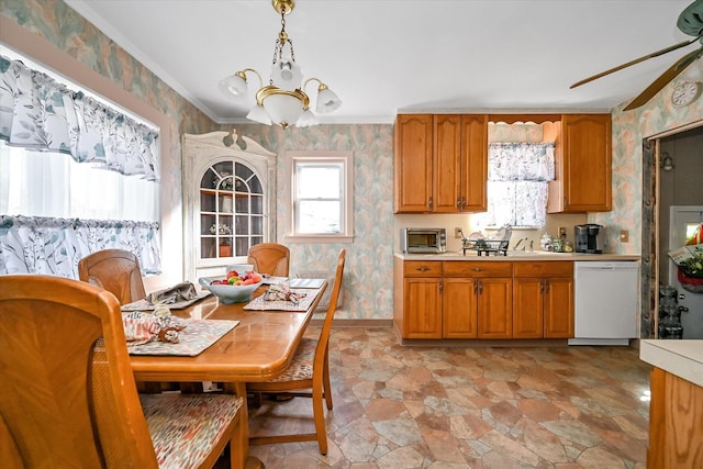 kitchen featuring sink, white dishwasher, hanging light fixtures, and ceiling fan with notable chandelier