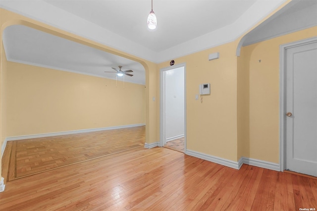 empty room with ceiling fan and light hardwood / wood-style floors