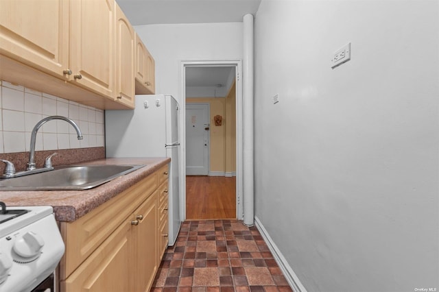 kitchen featuring backsplash, sink, white electric range oven, and light brown cabinets