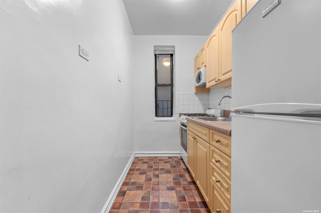 kitchen with sink, light brown cabinets, white appliances, and backsplash