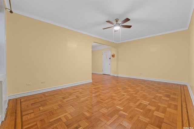 empty room with light parquet flooring, ceiling fan, and crown molding