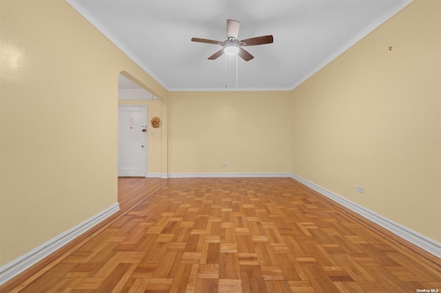 empty room with light parquet floors, ceiling fan, and ornamental molding