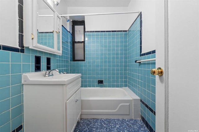 bathroom featuring tile patterned floors, shower / washtub combination, vanity, and tile walls