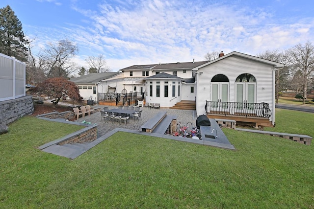 back of property featuring a yard, a patio, and a wooden deck