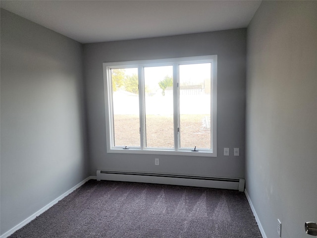 carpeted empty room with a baseboard heating unit