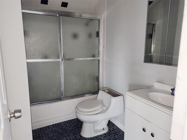 full bathroom with tile patterned floors, combined bath / shower with glass door, toilet, and vanity