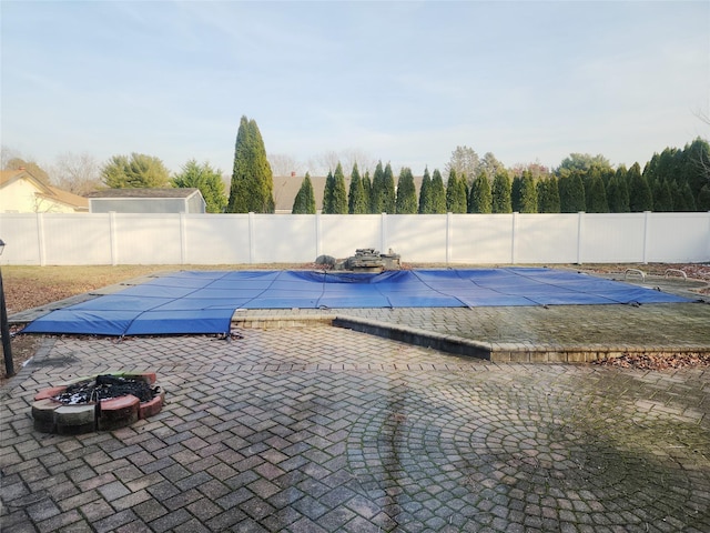 view of swimming pool with a patio and an outdoor fire pit