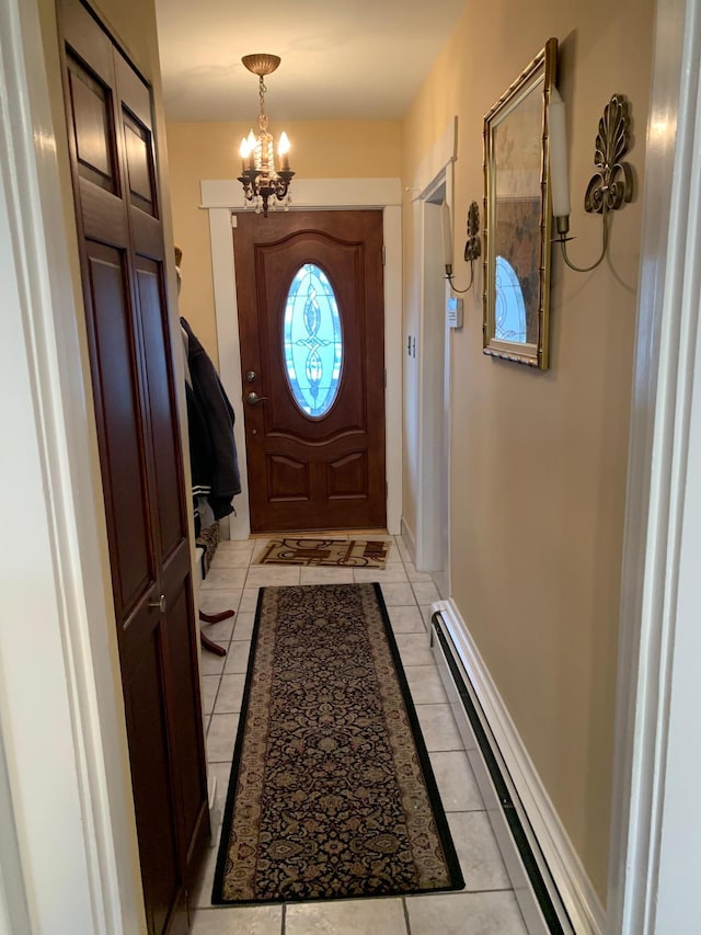 doorway to outside featuring a chandelier, light tile patterned floors, and a baseboard heating unit